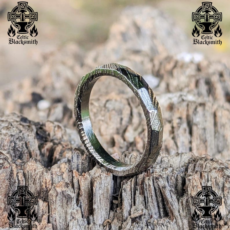 May include: A silver ring with a textured, hammered finish. The ring is made of metal and has a polished, shiny surface.