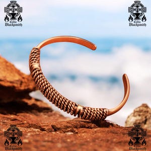 May include: A copper bracelet with a braided design. The bracelet is on a rocky surface with a blue and white background.