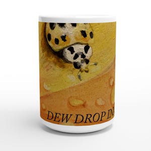 May include: White ceramic mug with a painted ladybug design, featuring black spots on a yellow background. The mug has the words "DEW DROP IN" printed in brown. The mug is cylindrical with a white handle. The mug is suitable for hot drinks.