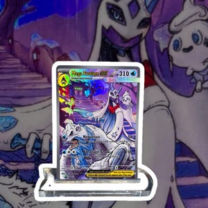 May include: A Mega Froslass EX trading card, featuring a detailed illustration of a snowy landscape with a large, white and blue character. The card has a holographic sheen and is displayed in a clear holder.
