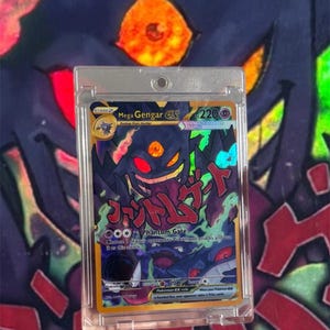May include: A Mega Gengar EX Pokemon card in a protective case. The card features a purple and black Gengar illustration with Japanese text and the words "Phantom Gate". The card has a holographic effect and a 220 HP rating.