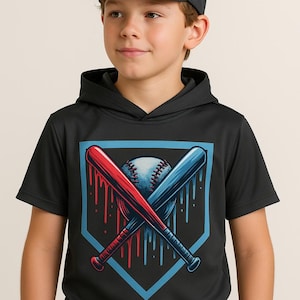 May include: A black hooded t-shirt featuring a baseball graphic. The graphic includes a baseball, crossed bats, and a home plate shape. The bats are red and blue, with a blue baseball. The person in the image is wearing a black baseball cap.