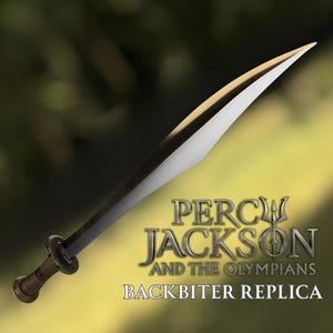 May include: A replica of the Backbiter sword from Percy Jackson and the Olympians. The sword has a silver blade with a dark grey spine and a brown handle. The text "PERCY JACKSON AND THE OLYMPIANS BACKBITER REPLICA" is displayed below the sword.