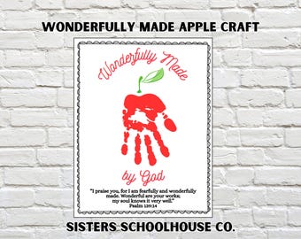May include: A white framed print with the text "Wonderfully Made Apple Craft". The artwork features a red handprint shaped like an apple with a green leaf. The text "by God" is below the apple.