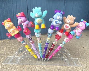 Bolígrafos con cuentas y personajes de Care Bears Rollerblading que elevan tu estación estacionaria.