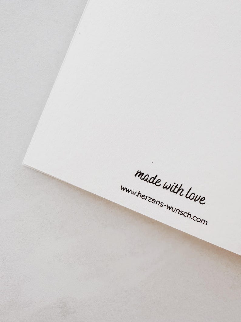 Puede incluir: Una tarjeta blanca con el texto "made with love" y la direcci&oacute;n del sitio web www.herzens-wunsch.com impresos en negro. La tarjeta est&aacute; en &aacute;ngulo, mostrando una esquina y el borde del papel.