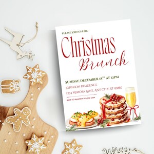 May include: A Christmas Brunch invitation with watercolor illustrations of food and a champagne flute. The invitation text is in red script and reads "Christmas Brunch" and includes the date, time, and location. Gingerbread cookies and wooden decorations are scattered around the invitation.