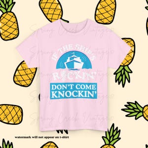 Puede incluir: Camiseta rosa claro con la frase "If the ships rockin' don't come knockin'" y un gráfico de un crucero. El diseño está rodeado por un patrón de piñas amarillas con hojas verdes.