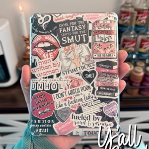 May include: A clear phone case with a variety of colorful stickers featuring phrases like "Came for the Fantasy Stayed for the Smut", "I Don't Watch Porn I Read It", "Stop Smut Shaming", and "Fueled by Smut & Sarcasm".