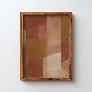 Op de afbeelding: Abstracte kunstprint in een houten lijst. Het kunstwerk heeft een geometrisch ontwerp met kleurvlakken in bruin-, beige- en wittinten. De houten lijst heeft een natuurlijke houtnerf afwerking, wat een rustieke touch toevoegt.