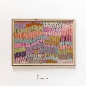 Puede incluir: Impresión artística abstracta en un marco de madera. La obra presenta un diseño colorido y texturizado con pinceladas verticales en tonos de rosa, naranja, amarillo y azul. La palabra "booma" está escrita en cursiva en la parte inferior del marco.