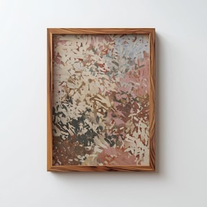 Puede incluir: Impresión artística abstracta en un marco de madera. La obra presenta un diseño texturizado y colorido con tonos de marrón, rosa, beige y gris. El marco de madera tiene un acabado de veta natural, añadiendo un toque rústico.