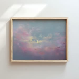 Könnte beinhalten: Gerahmtes Gemälde, das einen verträumten Nachthimmel darstellt. Das Kunstwerk zeigt einen gelben Halbmond vor einem Hintergrund aus pastellfarbenen rosa, lila und blauen Wolken. Der Holzrahmen verleiht eine natürliche Note.