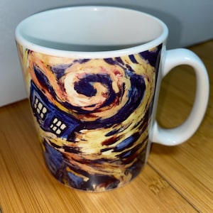 May include: White ceramic mug with a swirling, colourful design in the style of Van Gogh. The design includes a blue police box, a reference to the science fiction show. The mug has a white handle and interior.