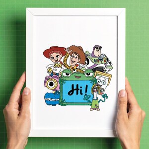 May include: A framed print featuring cartoon characters from the Toy Story franchise. The characters include Woody, Buzz Lightyear, Jessie, and others. A green frog-shaped sign displays the word "Hi!" in blue. The print is held in a white frame.