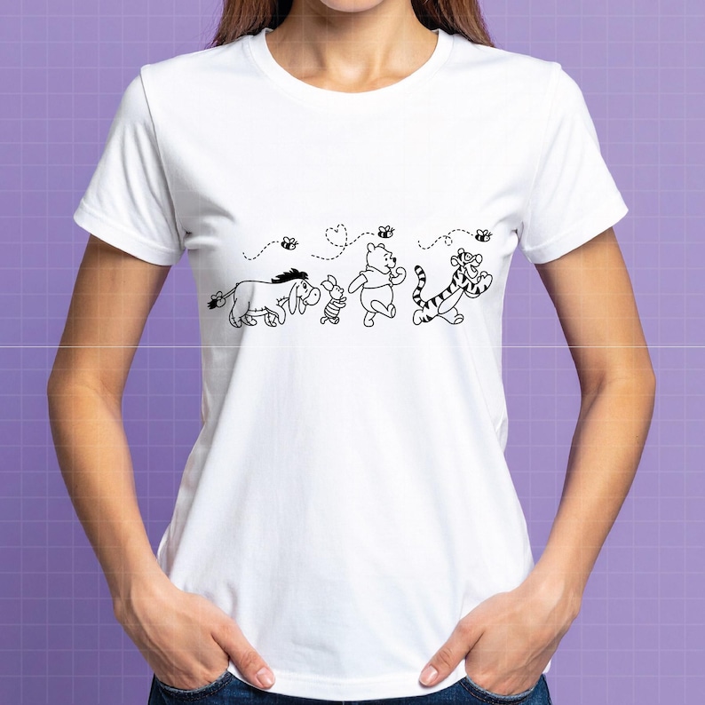 Puede incluir: Camiseta blanca con un dibujo lineal negro de los personajes de Winnie the Pooh: &Iacute;gor, Piglet, Winnie the Pooh y Tigger. El dise&ntilde;o incluye abejas y corazones. La camiseta tiene mangas cortas y cuello redondo.