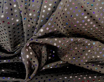 Peut inclure: Gros plan sur un tissu noir orné de sequins circulaires irisés. Le tissu est froissé et plié, créant des ombres et soulignant la texture du matériau. Les sequins reflètent un éventail de couleurs, dont le bleu, le violet et le vert.