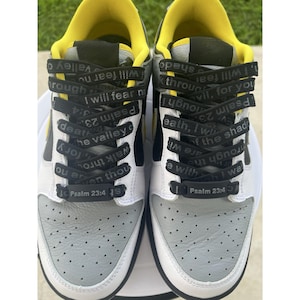 May include: Pair of white, gray, and yellow sneakers with black laces. The laces feature the text "I will fear no evil, for you are with me" and "Psalm 23:4". The shoes have a black swoosh and a white sole.