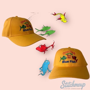 May include: Two yellow baseball caps with embroidered images of fish and the text "One Fish Two Fish Red Fish Blue Fish".