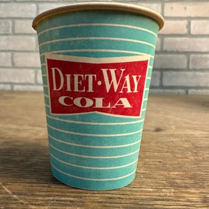 May include: A disposable paper cup featuring a teal and white horizontal striped pattern. The center displays a red, bow-tie shaped label with the white text Diet-Way Cola printed in a bold, serif font. The cup has a tan rim and a tapered shape.
