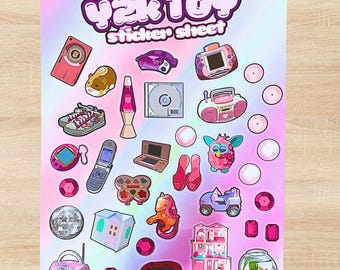 Op de afbeelding: Een stickervel met de titel Y2K TOY sticker sheet met diverse illustraties waaronder een digitale camera, hamster, lavalamp, cd, boombox, sneakers, handheld game, klaptelefoon, laptop, make-uppalet, poppenhuis en een discobal.