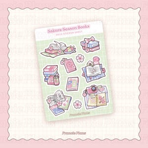 May include: A sticker sheet with the text "Sakura Season Books" and various illustrations of books, cherry blossoms, and a camera. The stickers are in shades of pink, green, and white, with a grid background. The brand name "Francie Plans" is at the bottom.