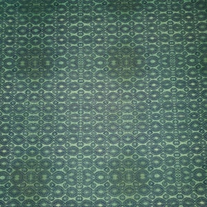 May include: A green fabric with a repeating pattern of dark blue ovals and circles.