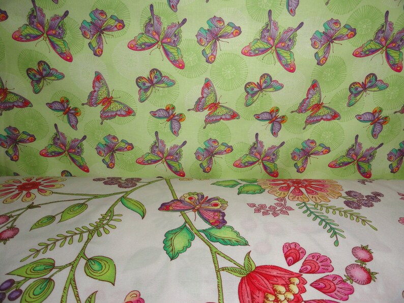 Puede incluir: Una tela verde con un patr&oacute;n repetitivo de mariposas coloridas. La tela tiene un fondo blanco con un patr&oacute;n floral.