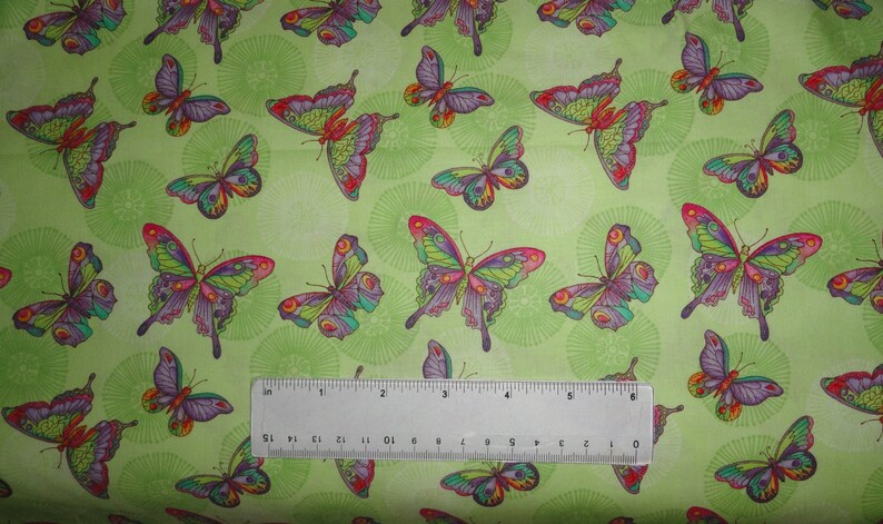 Puede incluir: Tela verde con un patr&oacute;n repetitivo de mariposas coloridas. Las mariposas tienen detalles intrincados y est&aacute;n dispuestas en un patr&oacute;n aleatorio.