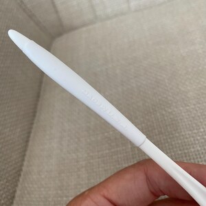 Puede incluir: Un objeto de pl&aacute;stico blanco con una punta. El texto "MADE IN U.S.A." est&aacute; impreso en el lateral. El objeto est&aacute; sostenido por una persona.