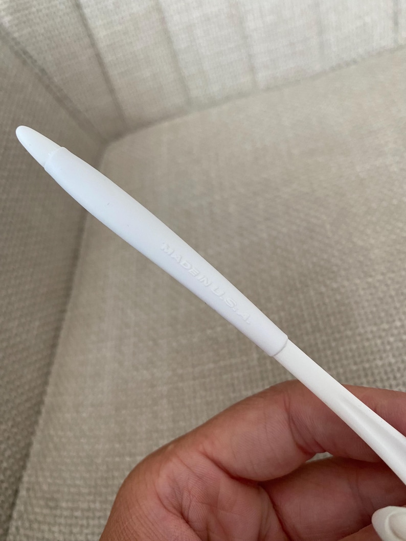 Puede incluir: Un objeto de pl&aacute;stico blanco con una punta. El texto "MADE IN U.S.A." est&aacute; impreso en el lateral. El objeto est&aacute; sostenido por una persona.
