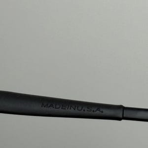 May include: Close-up of a black object with the text "MADE IN U.S.A." in white. The object appears to be a part of a larger item, possibly a tool or accessory.