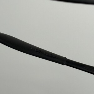 May include: Close-up of a black stylus pen with the text "MADE IN U.S.A." printed on the side. The pen is made of a matte black material and has a sleek, modern design. The image is set against a plain white background.