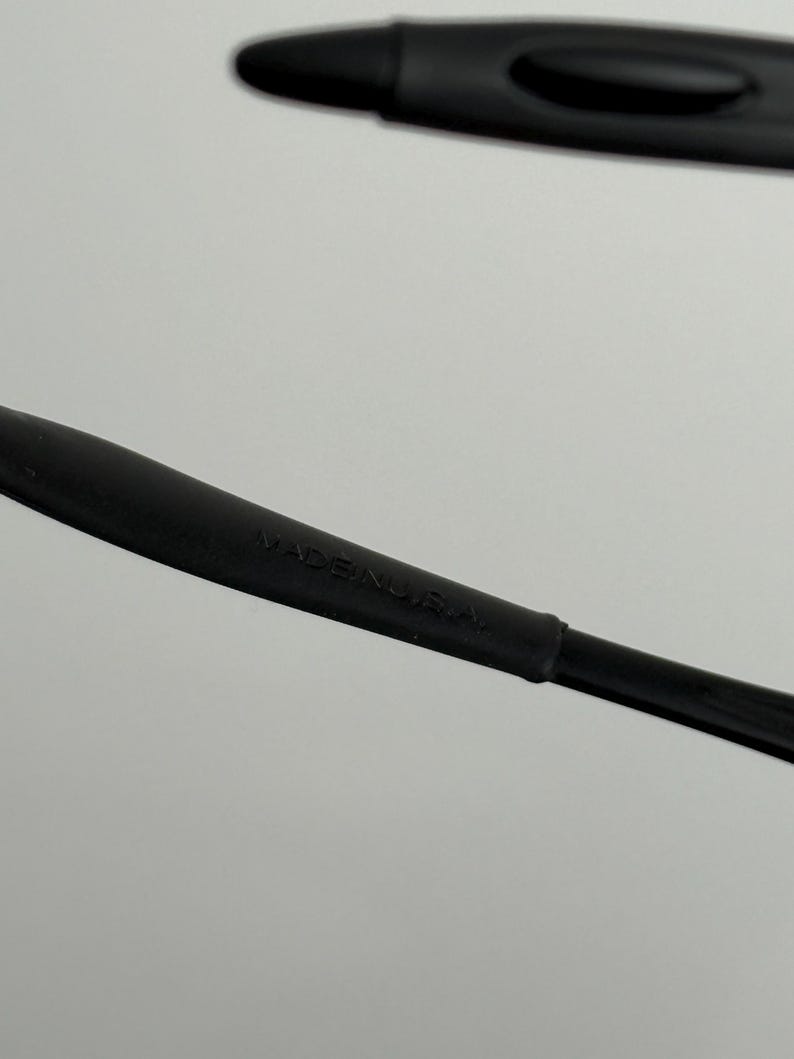 May include: Close-up of a black stylus pen with the text "MADE IN U.S.A." printed on the side. The pen is made of a matte black material and has a sleek, modern design. The image is set against a plain white background.