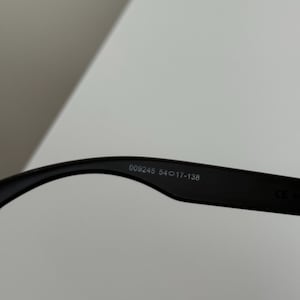 May include: Black eyeglasses with the text "009245 54017-138" printed on the inside of the arm. The glasses are set against a white background.