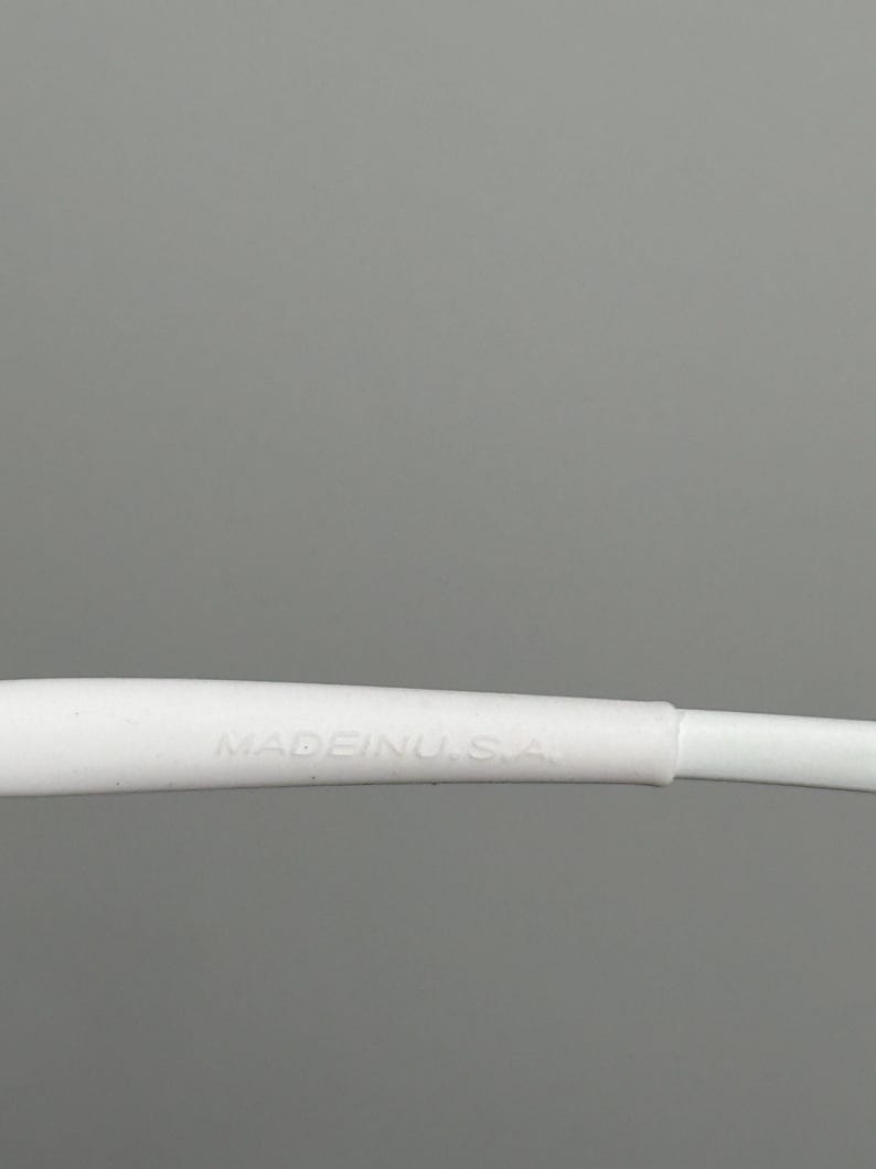 May include: Close-up of a white object with the text "MADE IN U.S.A." printed on it. The object is against a gray background.