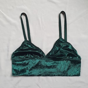 Puede incluir: Un bralette de terciopelo verde oscuro con tirantes ajustables.