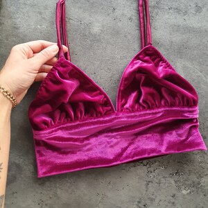 Op de afbeelding: Een roze fluwelen crop top met verstelbare bandjes. De top heeft een V-hals en een gerimpeld ontwerp.