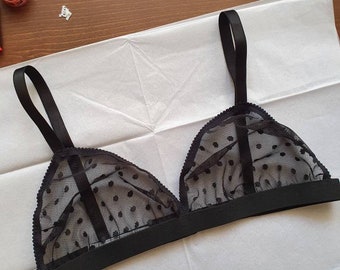 May include: A black triangle-shaped bra with polka dots and adjustable straps.