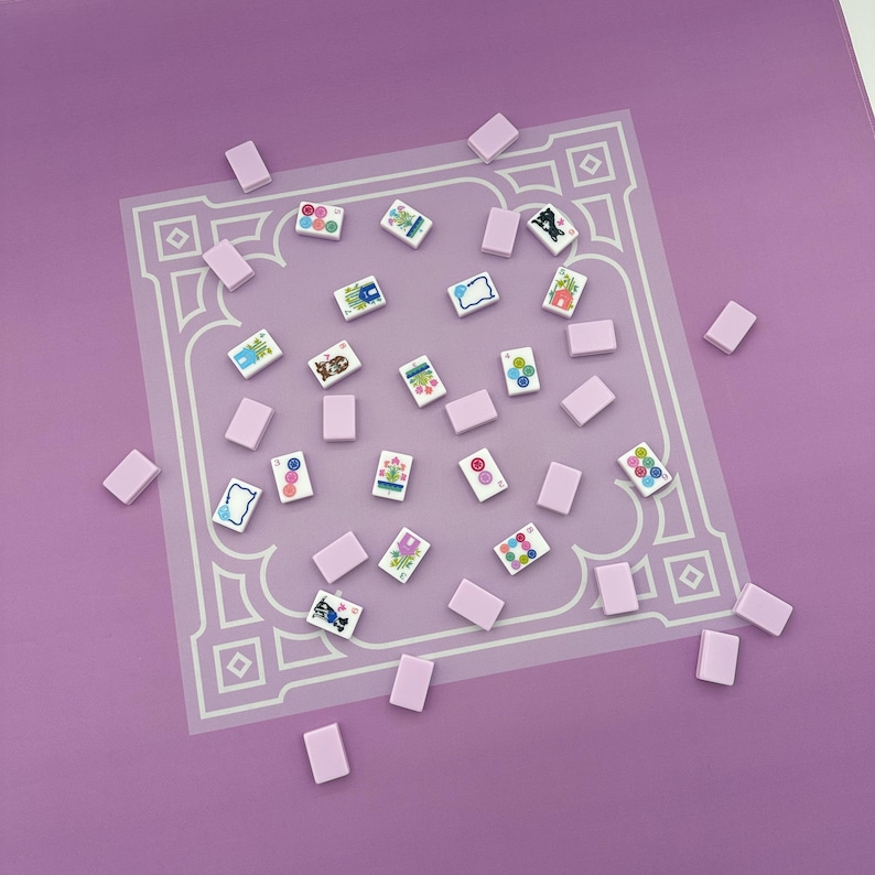 May include: A collection of small, rectangular, light purple tiles and decorative tiles with colorful illustrations scattered on a light purple surface. The decorative tiles feature various designs, including flowers and abstract patterns.