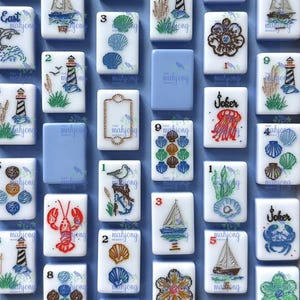 May include: A collection of white Mahjong tiles with nautical-themed illustrations. The tiles feature images of sailboats, seashells, lighthouses, and marine life, with numbers and the word "Joker" on some. The background is a light blue.