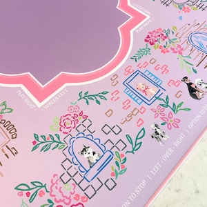 May include: A decorative, light purple game board with floral and dog illustrations. The board features a pink border and text that reads "PLAY RIGHT" and "WALLS LEFT". The design includes a variety of dog breeds and floral elements.