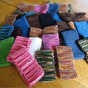 Op de afbeelding: Een verzameling kleurrijke gebreide vingerloze handschoenen in verschillende patronen en kleuren, waaronder groen, blauw, roze en bruin.