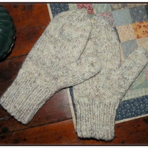 May include: A pair of knitted mittens in a beige and white color with a speckled pattern. The mittens are made of a soft, warm yarn and are perfect for keeping your hands warm in the winter.