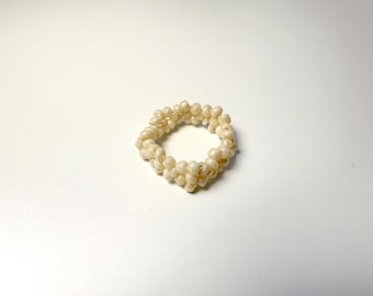 Anillo artesanal de cuentas de semillas color crema, minimalista, elástico y apilable.