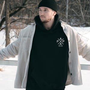 a man standing in the snow with his hands on his hips
