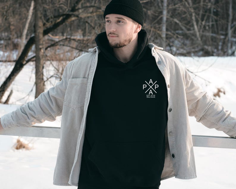 a man standing in the snow with his hands on his hips