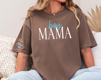 May include: Espresso-colored t-shirt with the words "boy MAMA" in white and blue script. The left sleeve has the names "Max" and "Ethan" with a blue heart. The shirt is a relaxed fit.