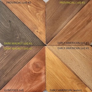 May include: A wooden sample board showcasing eight different wood stain colors. The colors include shades of brown, gray, and tan, with names like "Provincial," "Dark Walnut," and "Early American." Each sample is labeled with the stain type.