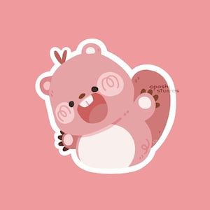 May include: A die-cut sticker featuring a cartoon beaver with pink fur, a white belly, and a wide, happy expression showing two front teeth. The beaver has a small heart shape above its head and the text opashi studios printed on its tail.